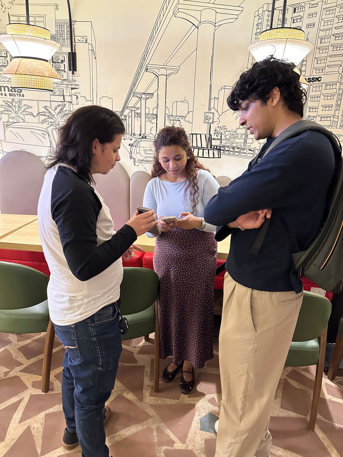A candid moment, three people looking at a phone together