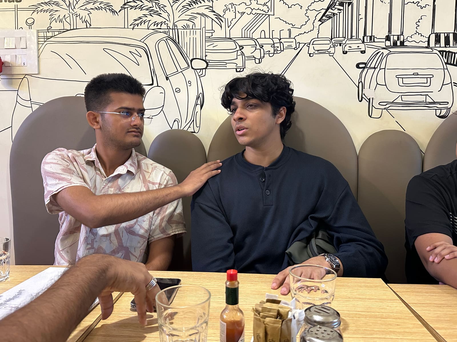 A hand on the shoulder — a mentorship moment mid-conversation