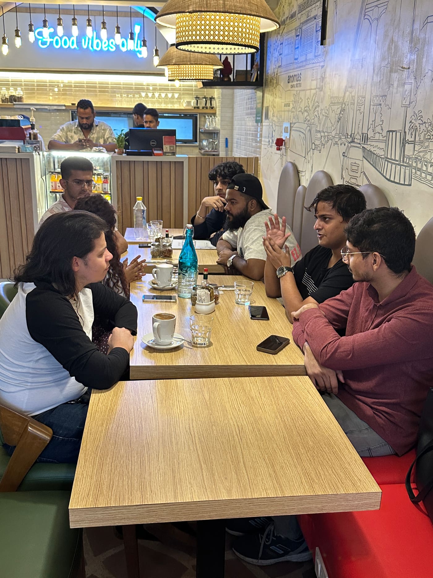 The table, seen wide, deep in discussion